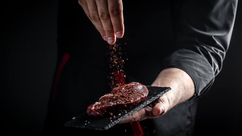 Person seasoning steak