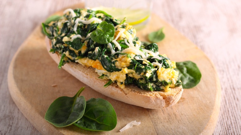 Scrambled eggs with spinach and cheese on toasted bread