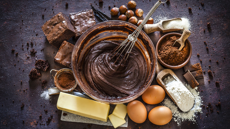 A bowl of batter surrounded by baking ingredients