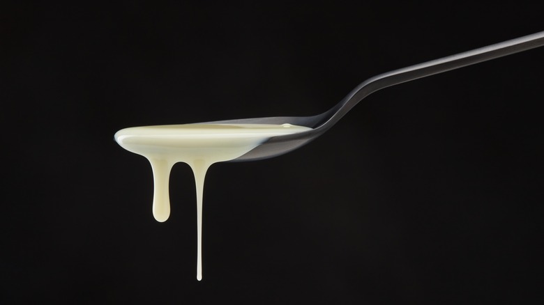Spoonful of thick cream on black background