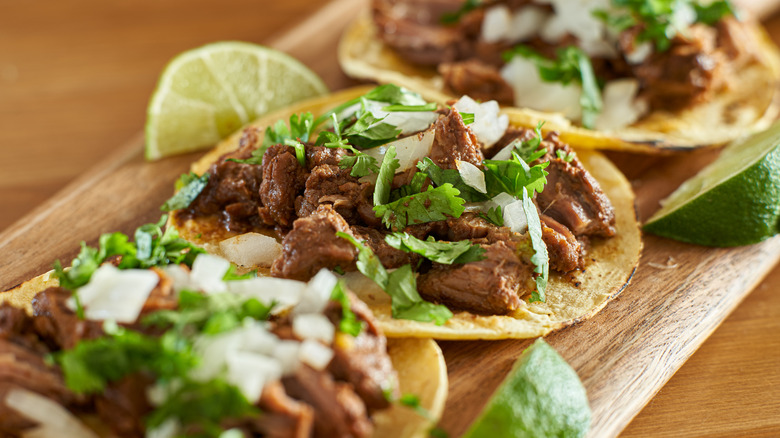 Carne asada steak tacos on corn tortillas with cilantro onions and lime