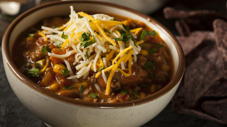 bowl of chili with shredded cheese on top