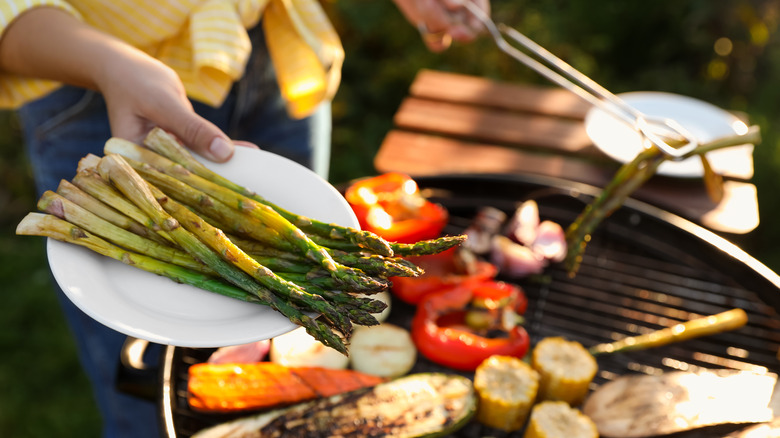 cook lifting asparagus off grill