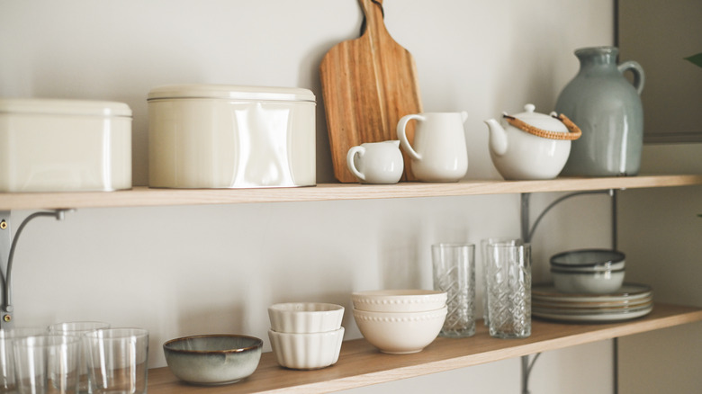 Open shelving in a kitchen styled with various cookware and dishware