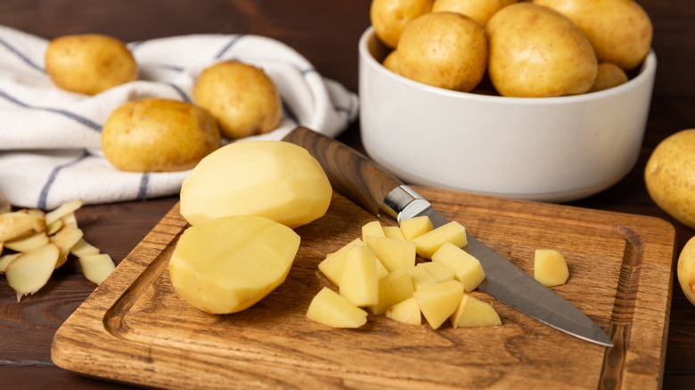 potatoes in bowl and cutting board next to knife