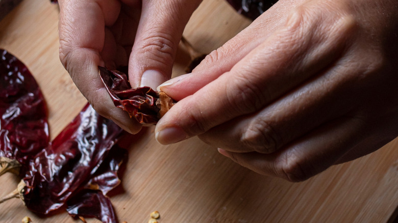 A person deseeding a guajillo chile