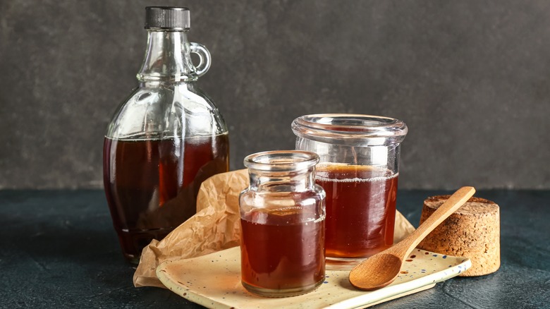 Glass bottle and jars of maple syrup