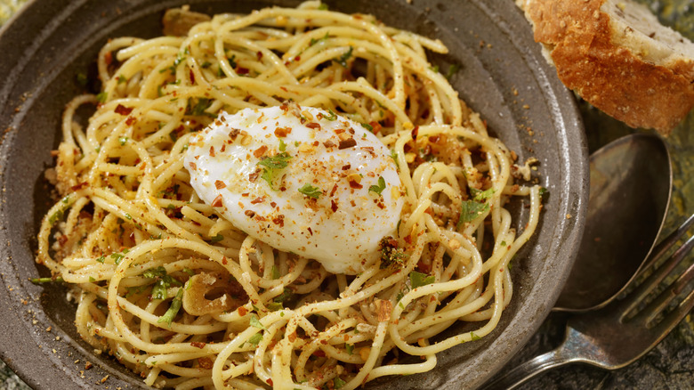 A poached egg on top of spicy pasta noodles