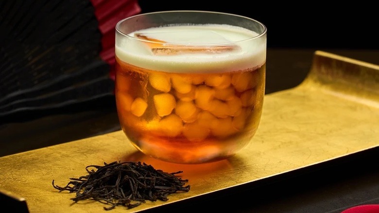 Herbal-infused cocktail on gold tray