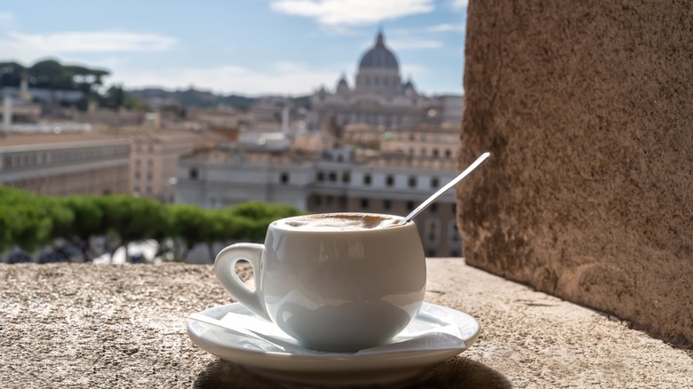 Cup of coffee on ledge overlooking Italian landscape