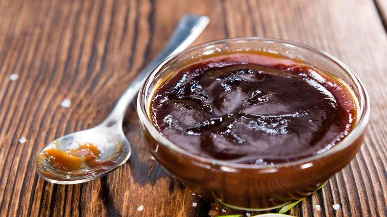 Dish of bbq sauce with spoon on side