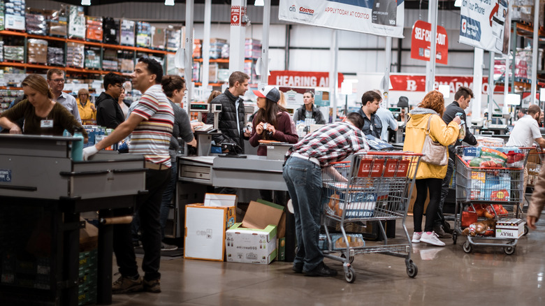 Many people wait in line at a Costco checkout area