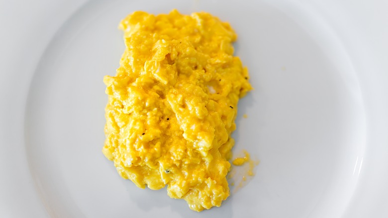 Creamy scrambled eggs on white plate