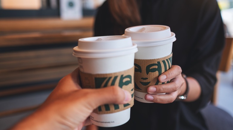 Two people with Starbucks cups