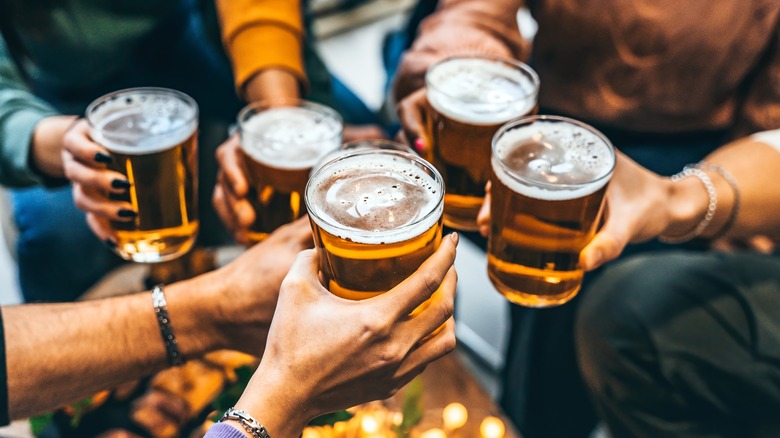 five people holding glasses of beer