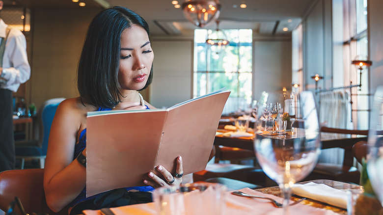 Woman looks through menu book