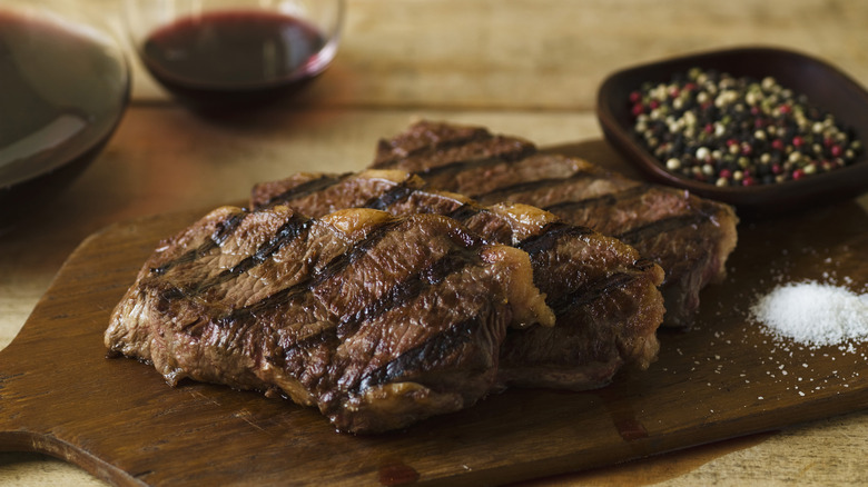 Grilled steak resting on a cutting board.