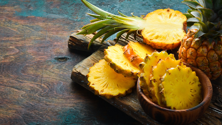 crosswise slices from a whole pineapple on a cutting board