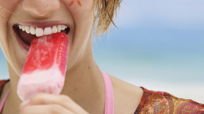 Person eating ice pop on beach