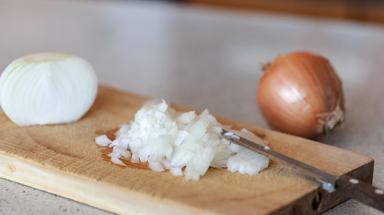 Chopping onions on a wooden cutting board