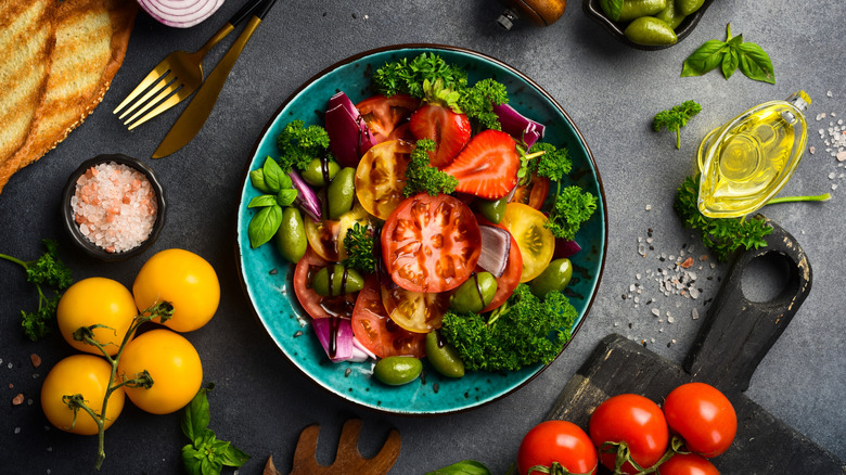 Colorful salad surrounded by a variety of ingredients