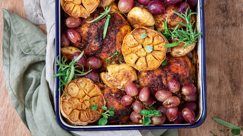 Roast chicken thighs with grapes and garlic in a pan