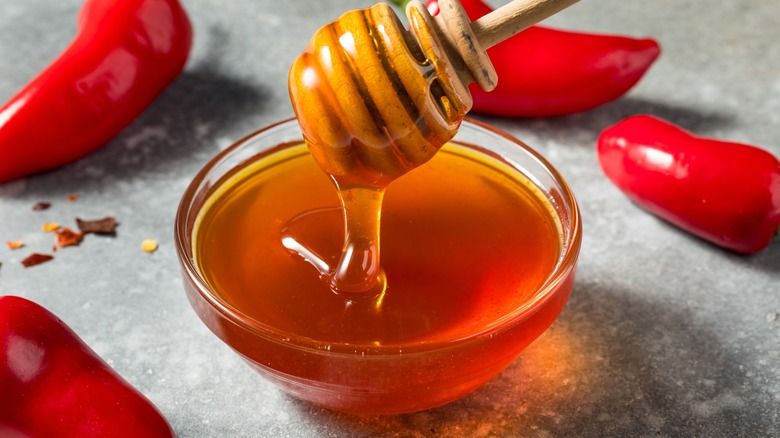 hot honey in a dish with peppers in the background