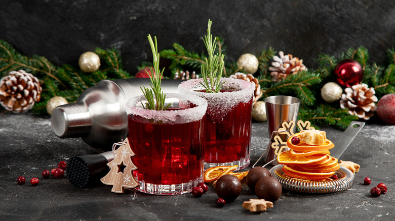 Holiday cocktails next to Christmas decor and cocktail making accessories