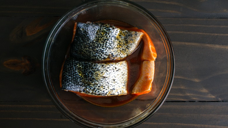 Salmon marinating in glass bowl