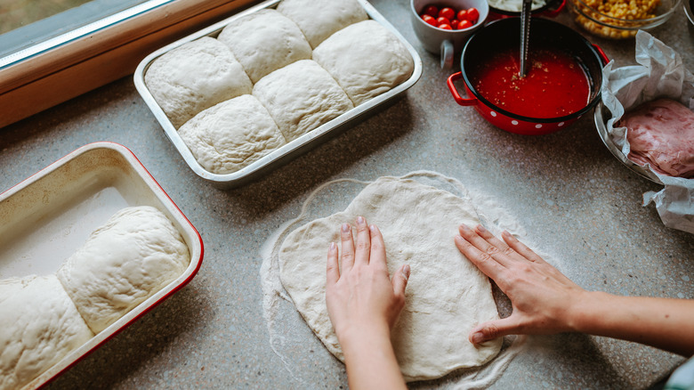 Preparing pizza dough at home with other pizza ingredients