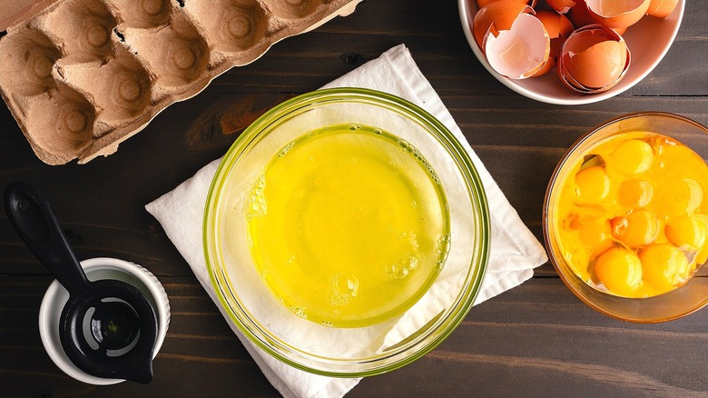 Clear bowl of separated egg whites over folded white cloth napkin