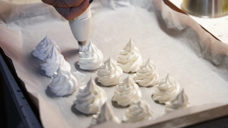 person piping meringue cookies 