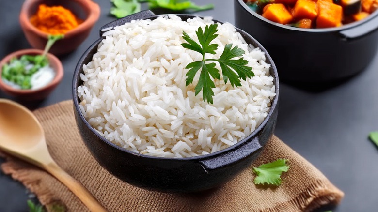 Cooked rice in an iron pot garnished with herb