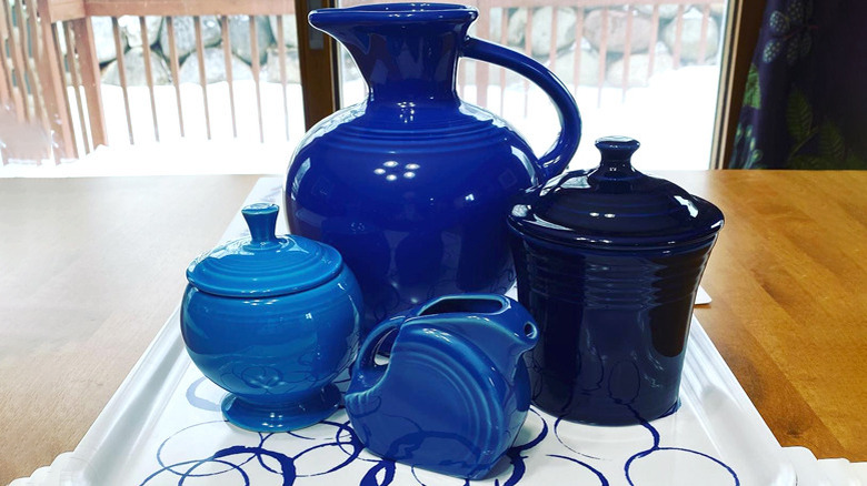 Collection of vintage blue Fiestaware on tray with pitcher, jug, and jars