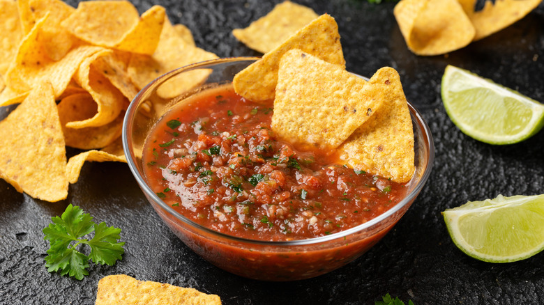 Salsa and tortilla chips, limes on side