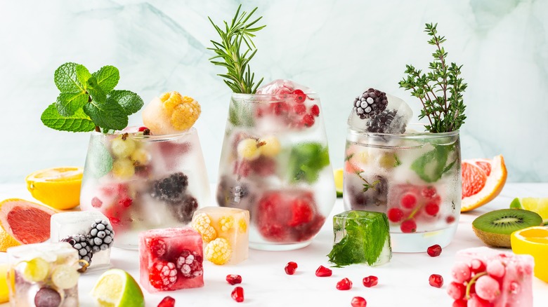 Ice cubes with frozen fruit and herbs