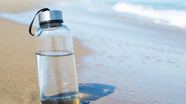 Glass water bottle on beach