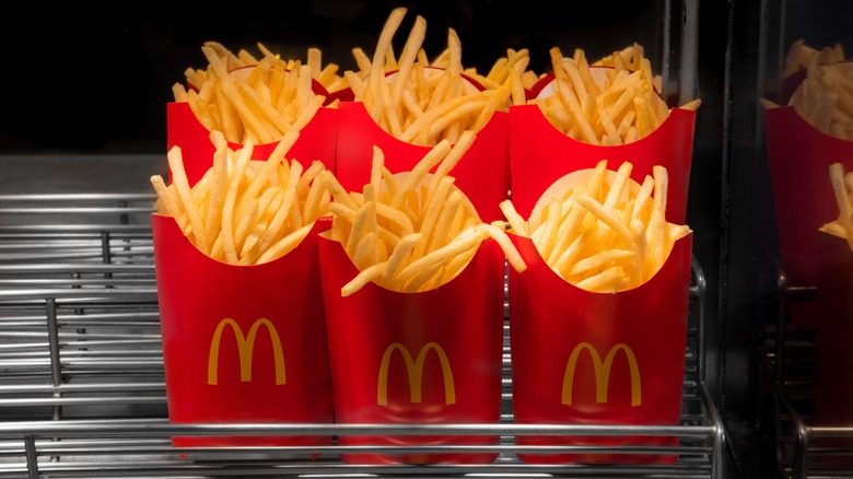 Six pouches full of McDonald's french fries sit on a warming rack