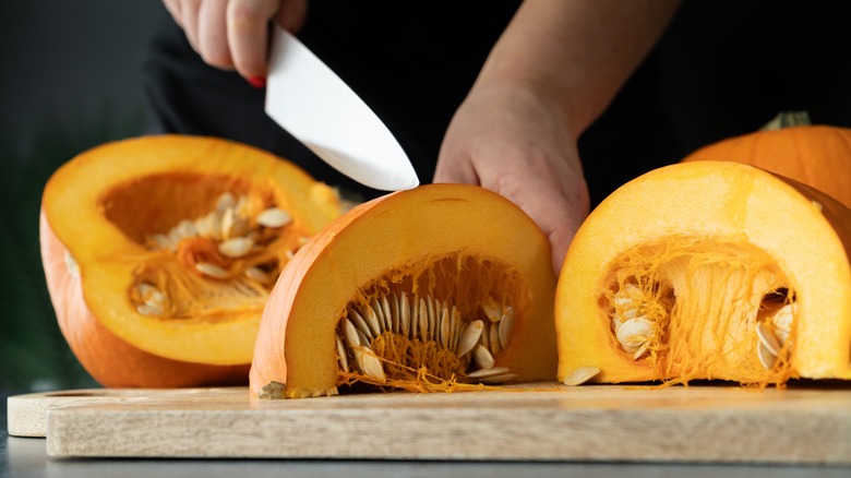 Person cutting pumpkins on chopping board