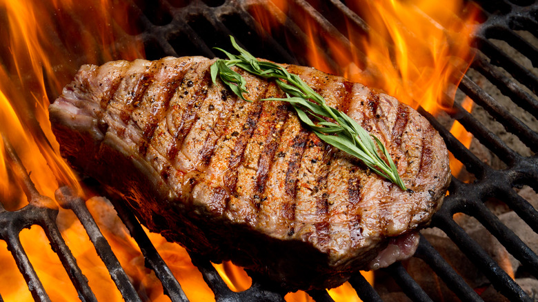 Ribeye steak over fire on grill