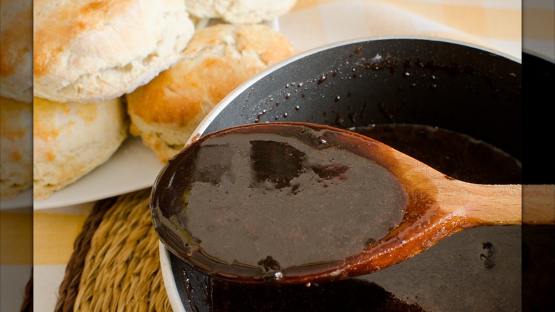 Chocolate gravy in spoon to be poured over biscuits