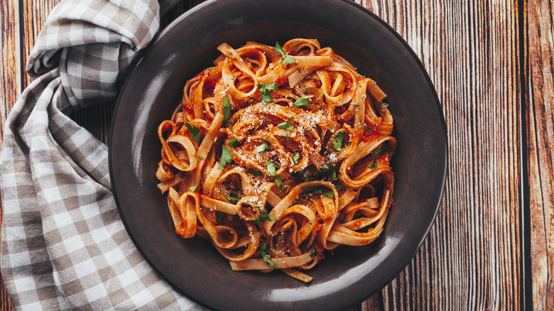 Tagliatelle with tomato sauce on black plate