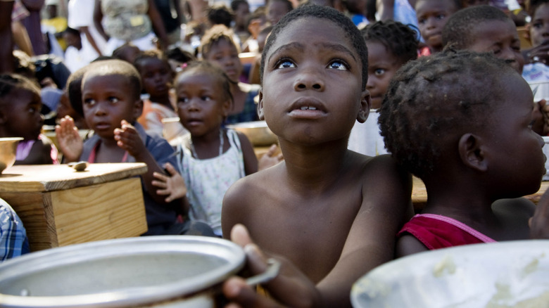 Haitian children waiting for food handout in camp
