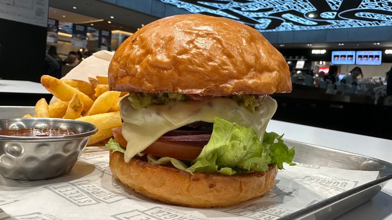 A hamburger, fries, and a dish of sauce in a Gordon Ramsay restaurant