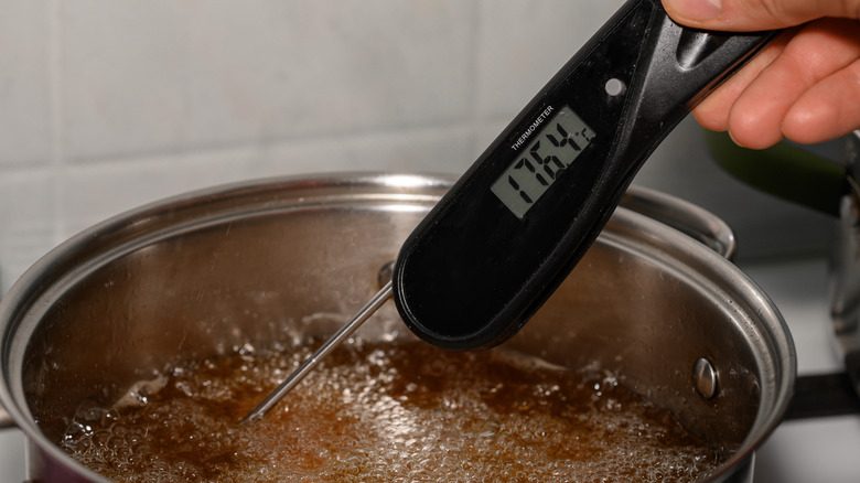 Using a probe thermometer to check the temperature of frying oil