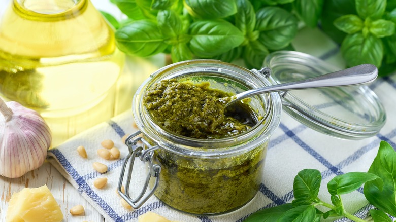 A jar of homemade pesto with a spoon