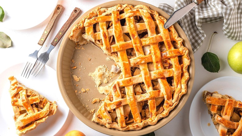 Lattice top apple pie in pan with piece cut out