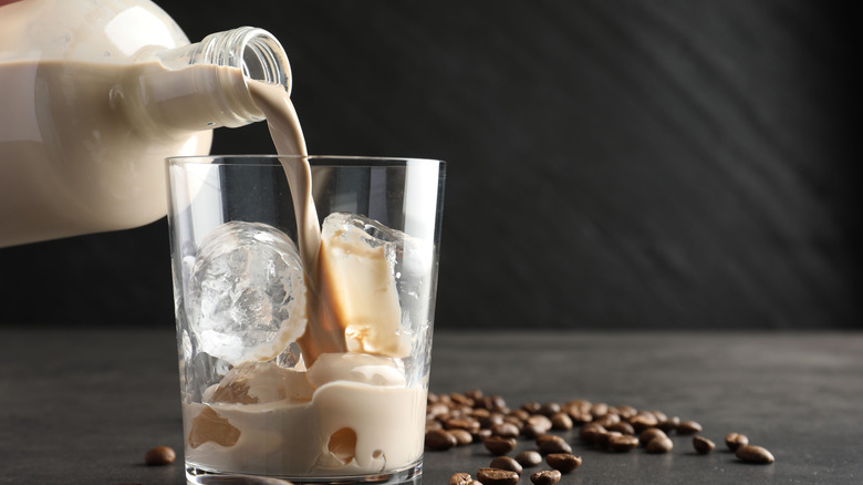 Irish cream liqueur being poured into a glass with ice