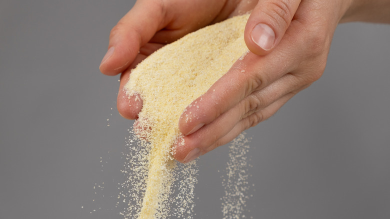 Semolina flour spilling from a pair of cupped hands