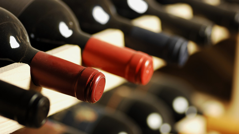 Rows of wine bottles sitting in a cellar